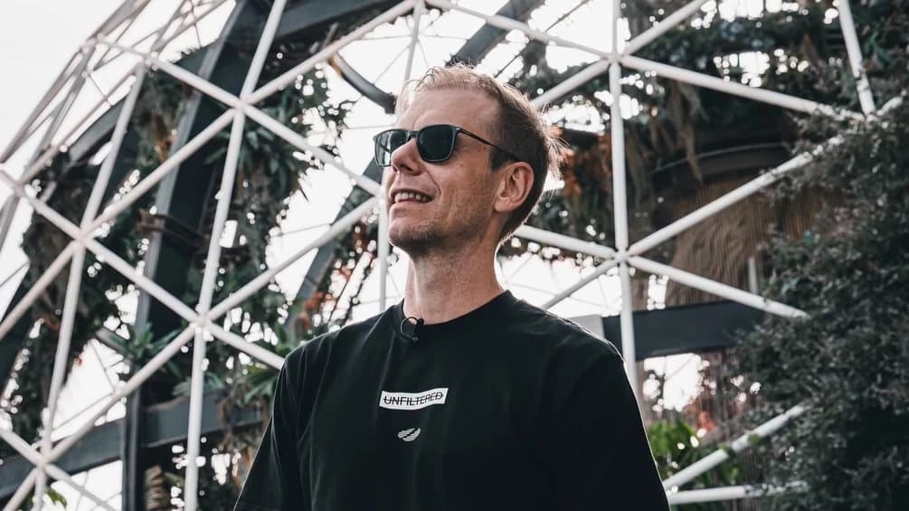 Armin van Buuren w okularach przeciwsłonecznych pod stalową kopułą porośniętą roślinami