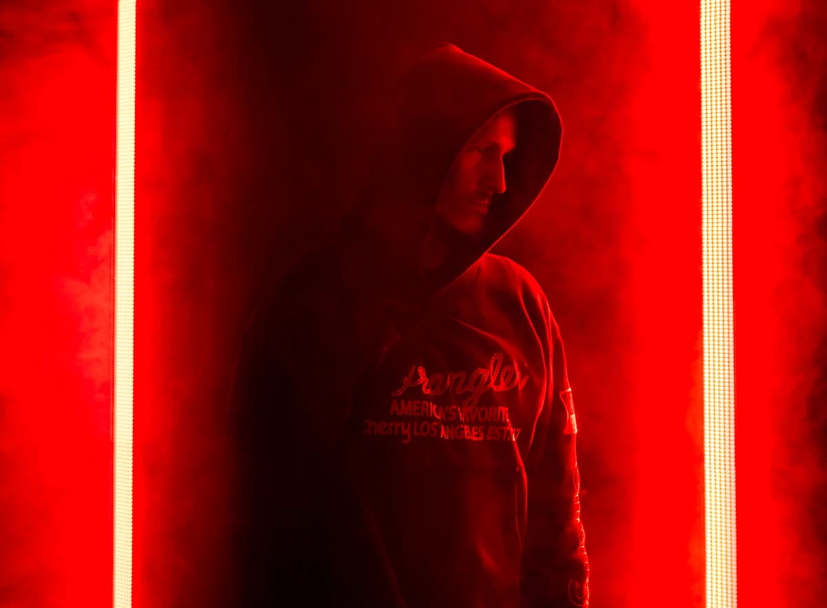 Kaskade w kapturze na tle czerwonych neonów, zdjęcie promocyjne