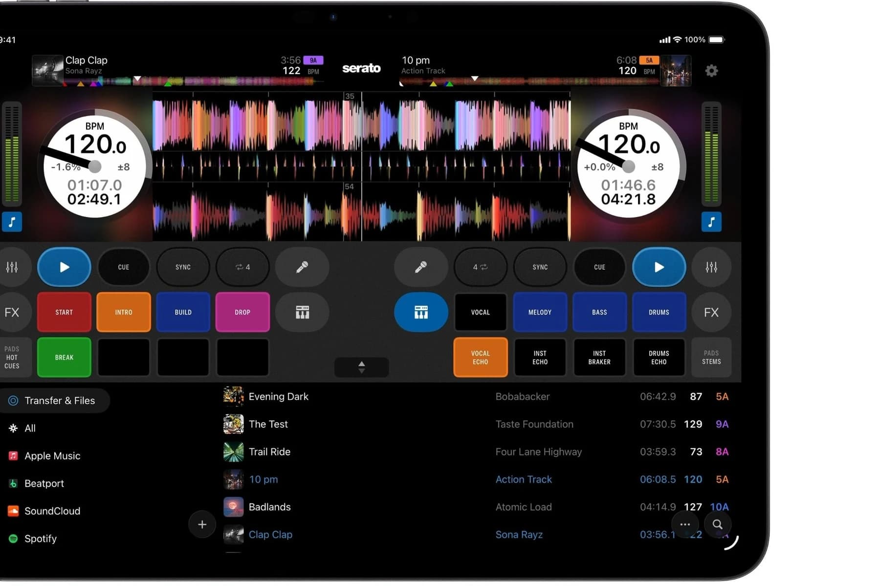 Ciemny interfejs Serato DJ na ekranie urządzenia z iOS: dwa deki z tarczami BPM, kolorowe przebiegi fal, pady START, INTRO, BUILD i DROP oraz biblioteka ze źródłami Apple Music, Beatport, SoundCloud i Spotify.